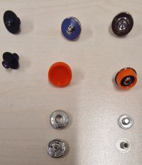 Exemple : boutons-pression anorak 12 mm. À gauche : outils de perçage. Au centre : embouts et pièces femelles. À droite : embouts et pièces mâles.